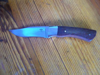 Small hunting knife with solid harwood handle and mirrior finished stainless steel bolsters.